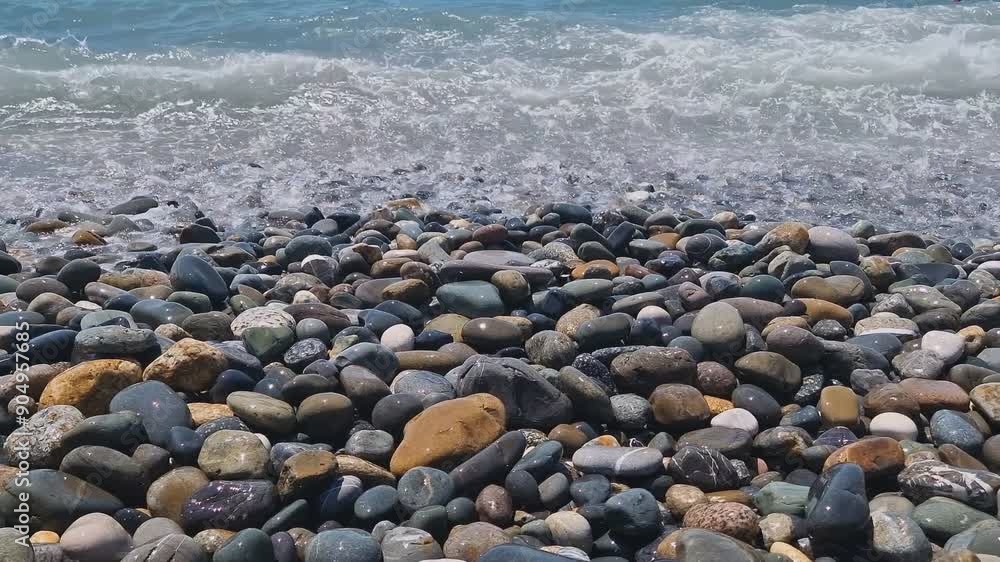 Waves break on the rocks on the beach, sea spray, sunlight is reflected in the water. Waves break on the rocks on the beach, sea spray, sunlight is reflected in the water.