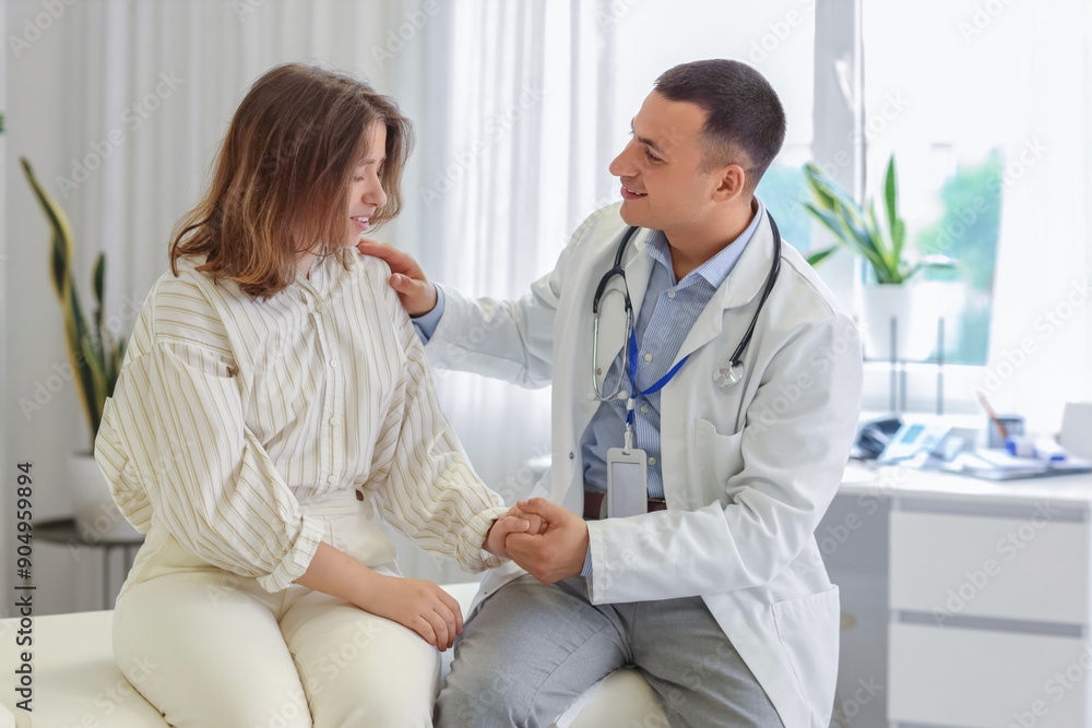 Obraz premium Handsome doctor working with patient in clinic