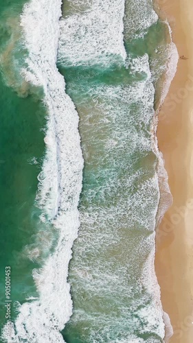 Phuket Thailand tropical beach Aerial drone top down view bird eye view of sea blue waves break on sand. Beautiful of sea water wave rip current reverse current undertow drone filming 4k vertical.