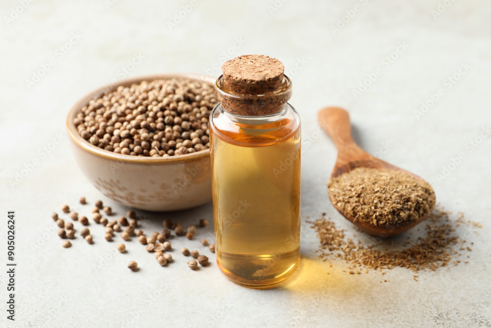 Coriander essential oil, powder and seeds on light grey table Coriander essential oil, powder and seeds on light grey table