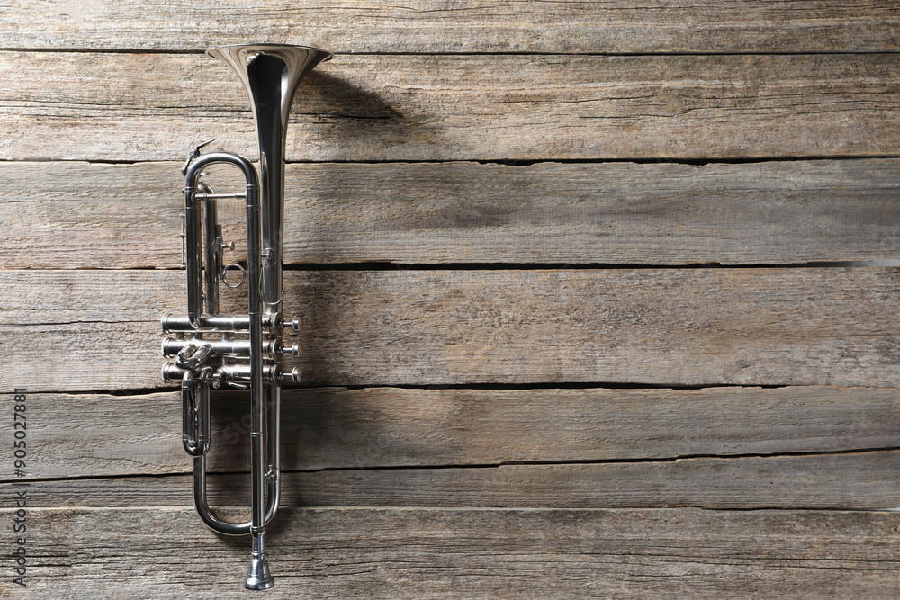Fototapeta premium Trumpet on wooden table, top view. Space for text