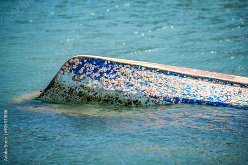 A small old fishing boat is capsized on the sea with bottom up and filled with oyster shell on surface at Cheongsando Island near Wando-gun, South Korea
 photo