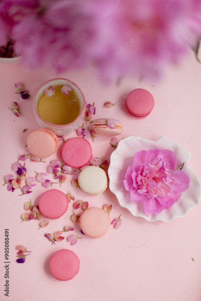 macaroon cookies, a flower on a plate and a cup of tea macaroon cookies, a flower on a plate and a cup of tea