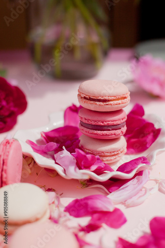 pink cookies on a plate and flower petals next to it