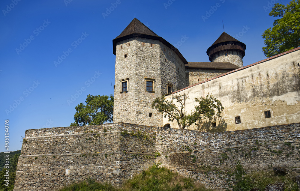 Stone castle. Castle complex with buildings, tower and walls. Nd castle blue sky with white clouds. Castle, walls, roof. Stone castle. Castle complex with buildings, tower and walls. Nd castle blue sky with white clouds. Castle, walls, roof.