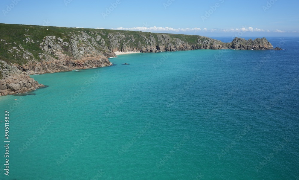 View of Pedn Vounder Beach and Logan Rock surrounded by blue sea. Cornwall, UK. View of Pedn Vounder Beach and Logan Rock surrounded by blue sea. Cornwall, UK.