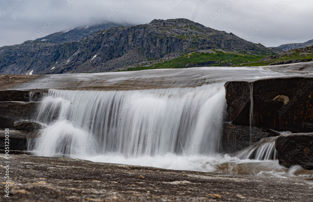Small waterfall flowing over stones in the mountains of Rago, Northern Norway Small waterfall flowing over stones in the mountains of Rago, Northern Norway