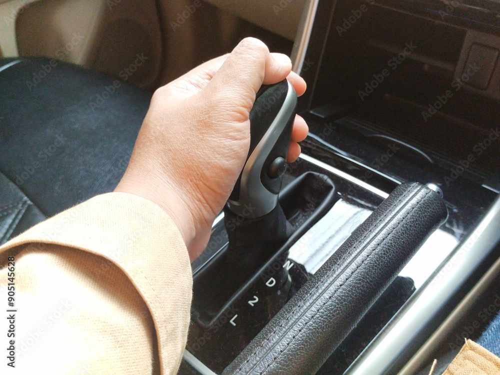 A driver's hand holds the transmission lever of an automatic car A driver's hand holds the transmission lever of an automatic car