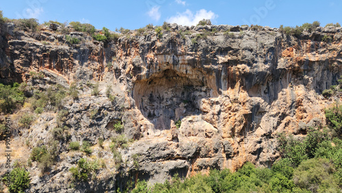 The rocky cliffs in the western side of the Heaven Sinkhole in the touristic site called Cennet-Cehennem caves photo