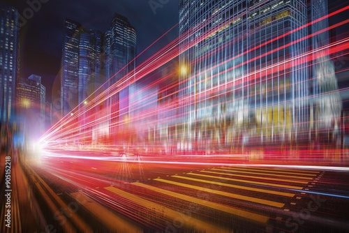 A city street at night with tall buildings in the background, illuminated by bright red and white streaks of light from passing cars. photo