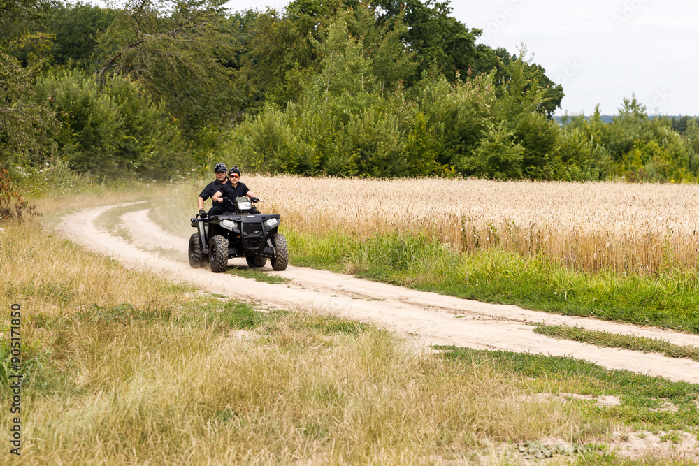 The rescuer, a beautiful athletic physique, rides an ATV in the middle of the field The rescuer, a beautiful athletic physique, rides an ATV in the middle of the field