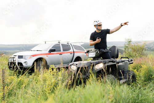 The rescuer, a beautiful athletic physique, rides an ATV in the middle of the field