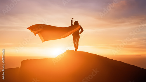 Silhouette businesswoman wearing cape and rise fist up standing on top of mountain. concept of woman power, business success, leadership, target goal achieve, winner