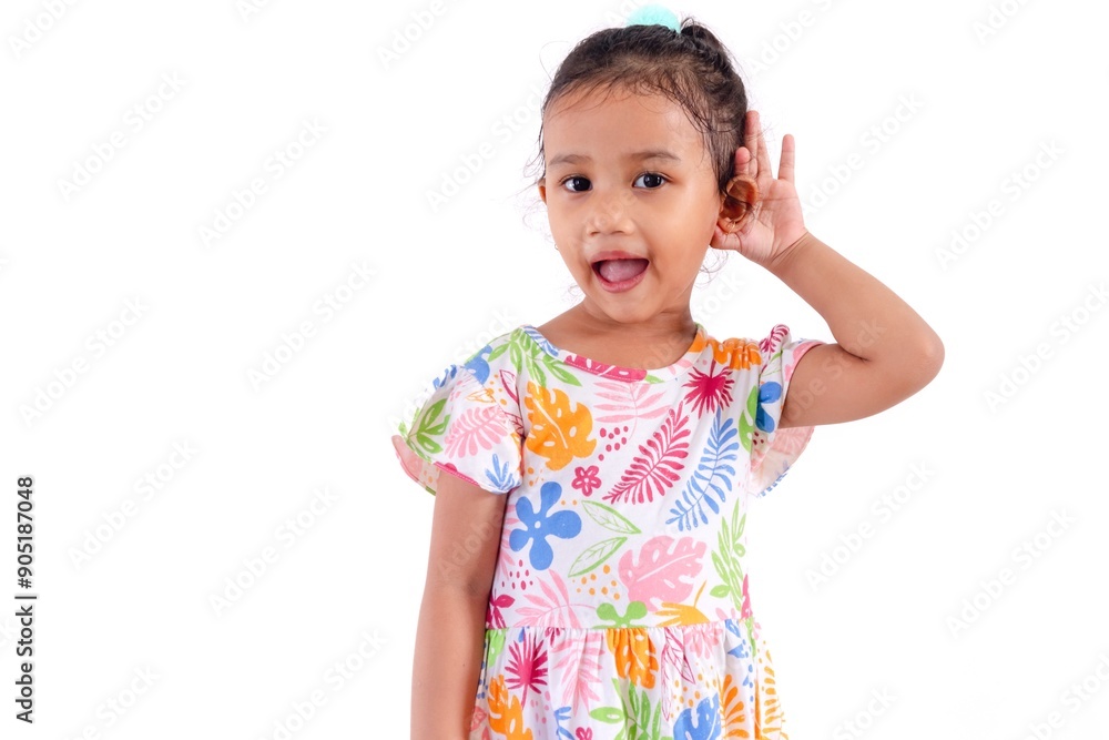 Attractive little Asian girl in a colorful dress holding one ear as if listening to something, on a white background. Attractive little Asian girl in a colorful dress holding one ear as if listening to something, on a white background.