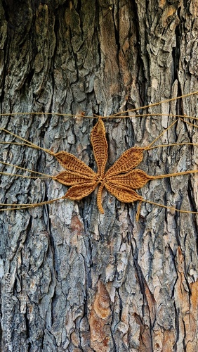 knitted chestnut leaf on texture of tree bark photo