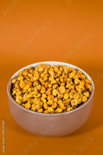 Corcflakes or Marning or marneng is traditional snack from indonesia. Made from corn kernels that fried. Fried corn in bowl with isolated background photo