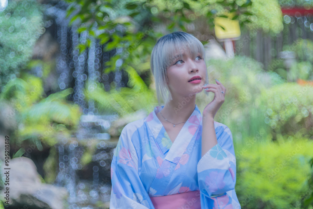 Pretty girl in a Yukata dress. Portrait fashion young Asian women wearing a traditional Japanese kimono or Yukata dress and holding pink umbrella are happy and relaxing in the fresh green nature. Pretty girl in a Yukata dress. Portrait fashion young Asian women wearing a traditional Japanese kimono or Yukata dress and holding pink umbrella are happy and relaxing in the fresh green nature.