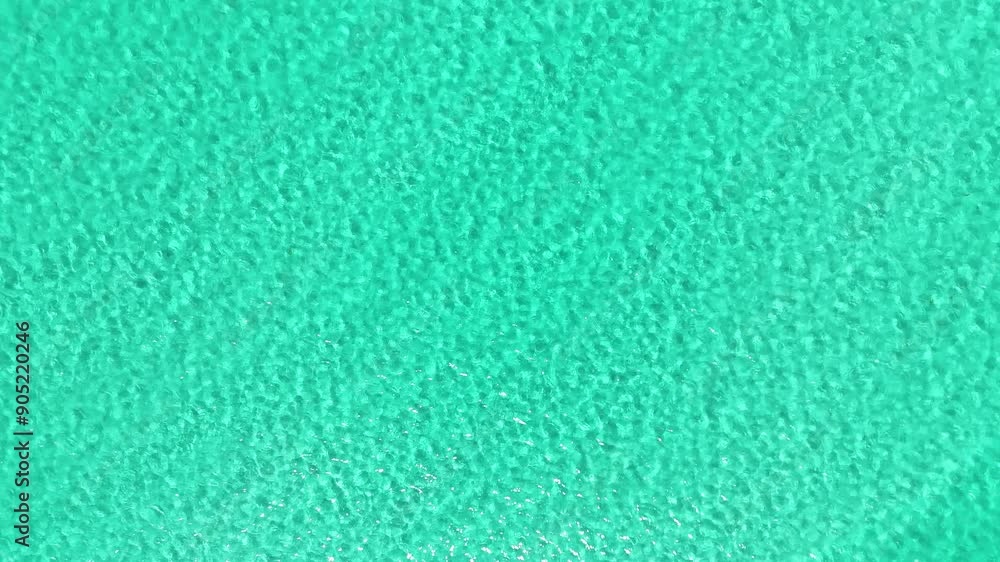 Gentle waves dance in the turquoise sea, captured from above Gentle waves dance in the turquoise sea, captured from above
