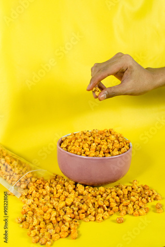 Corcflakes or Marning or marneng is traditional snack from indonesia. Made from corn kernels that fried. Fried corn in bowl with isolated background photo