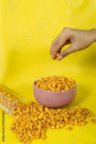 Corcflakes or Marning or marneng is traditional snack from indonesia. Made from corn kernels that fried. Fried corn in bowl with isolated background photo