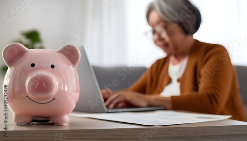 Toy pink piggy bank on work table of senior tenant, homeowner woman. Elderly lady using calculator, counting savings, taxes. Finance management, financial insurance