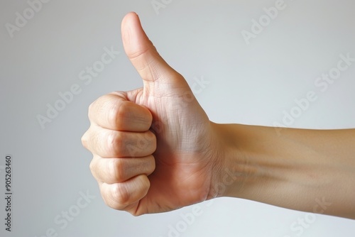 Uplifting Gesture of Approval, A Thumbs Up Hand on White Background Signifying Praise and Encouragement in a Clear and Simple Visual. photo