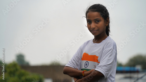 Little girl giving salute, wearing indian tricolor flag Tshirt and face painted with Indian flag colours. Indepence day celebration or Republic day. photo