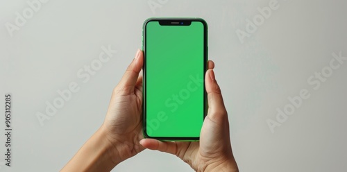 Hand holding smartphone with blank green screen, isolated on white background