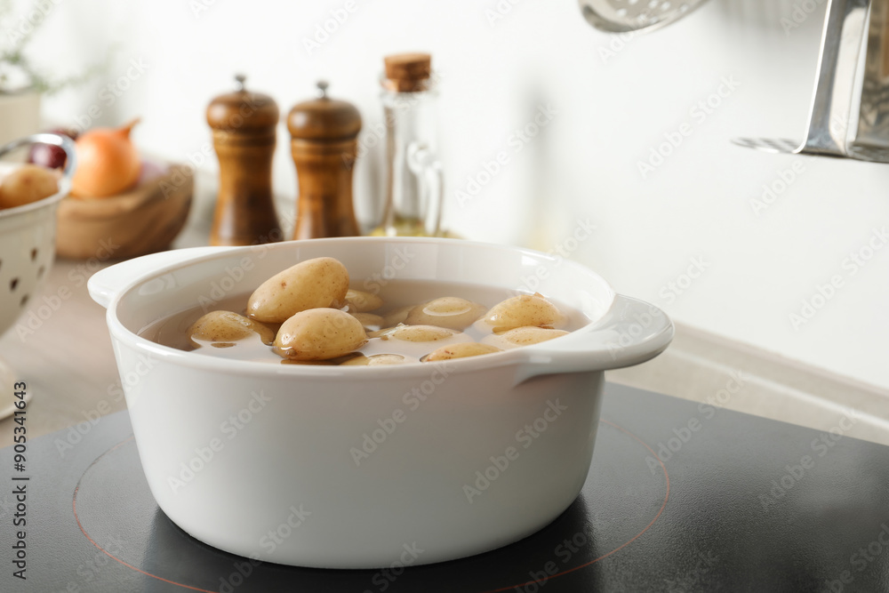 Boiling potatoes in pot on stove in kitchen Boiling potatoes in pot on stove in kitchen
