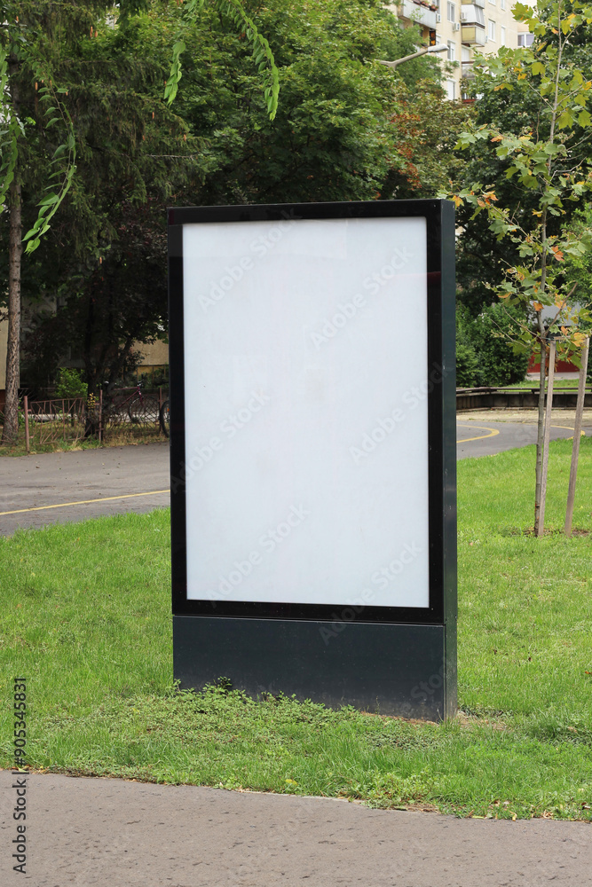 Blank advertising vertical street billboard poster in a green park mockup template. Empty white city light poster mock up template. Blank advertising vertical street billboard poster in a green park mockup template. Empty white city light poster mock up template.