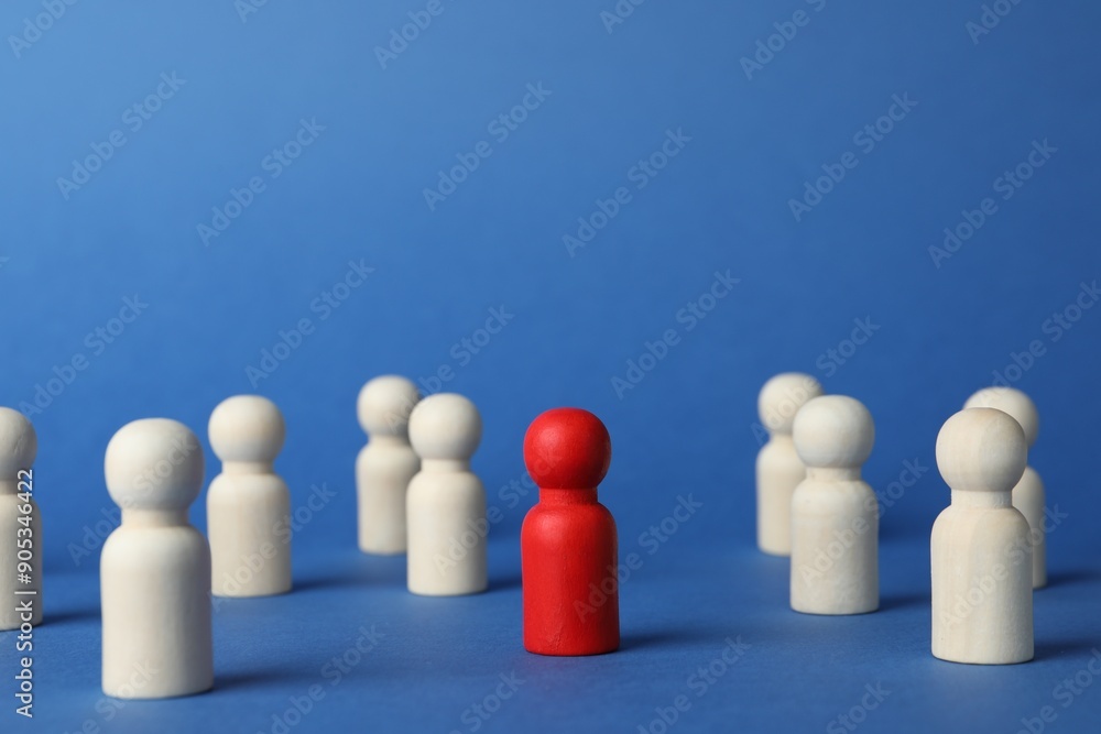 Red piece among wooden ones on blue background Red piece among wooden ones on blue background