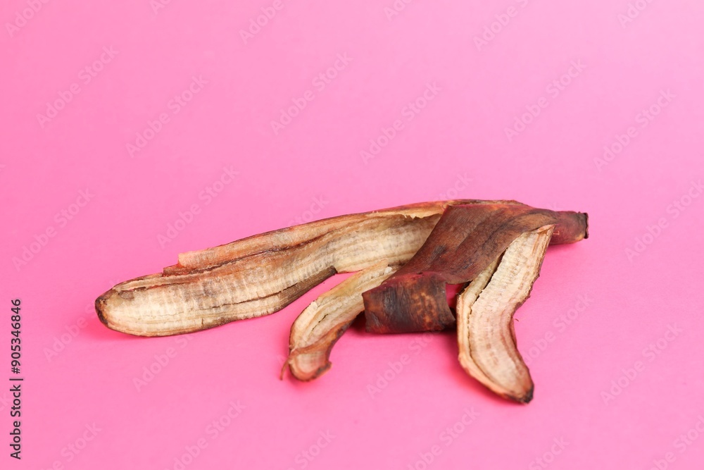 Banana peel with dark spots on pink background Banana peel with dark spots on pink background