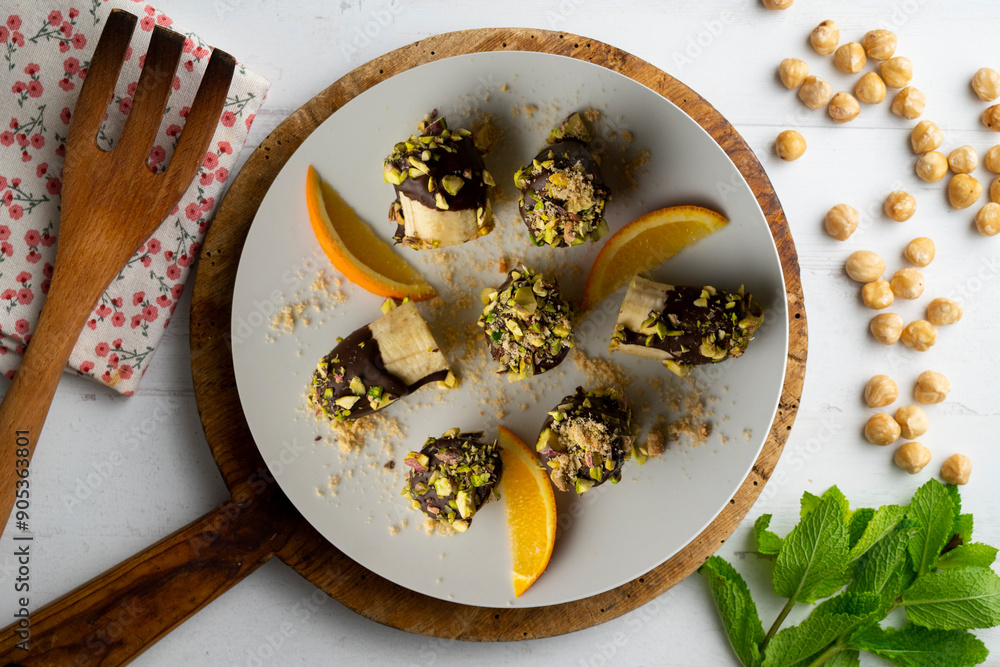 Delicious pieces of banana dipped with chocolate and pistachio. Delicious pieces of banana dipped with chocolate and pistachio.