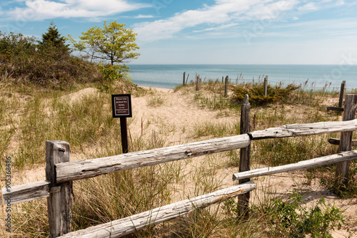 Split rail fence to keep people from walking over the sand dunes which removes their protective vegetation, and a sign stating no walkway at Point Beach State Park, Two Rivers, Wisconsin