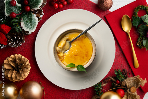 Fotografie Crema Catalana or La crème brûlée seen from an overhead perspective on a table decorated with christmas ornaments