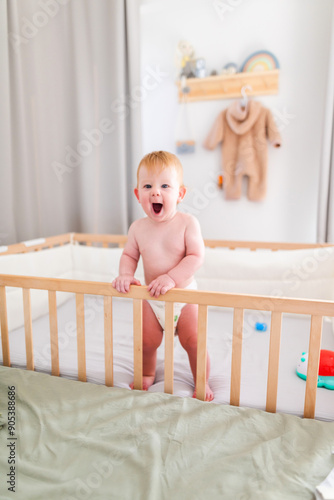 Wallpaper Mural an emotional baby standing in a crib with a diaper on. Torontodigital.ca