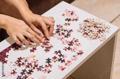 Unrecognizable person sorting a pile of puzzle pieces