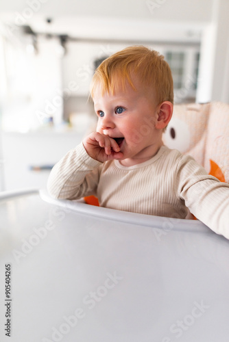 an emotional toddler sitting in a highchair.leery eye