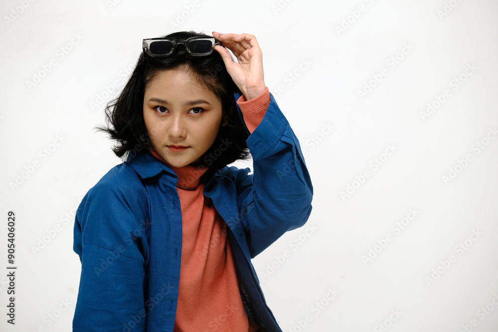 Beautiful Indonesian or asian young woman takes off glasses and putting on her head, looking at camera Beautiful Indonesian or asian young woman takes off glasses and putting on her head, looking at camera