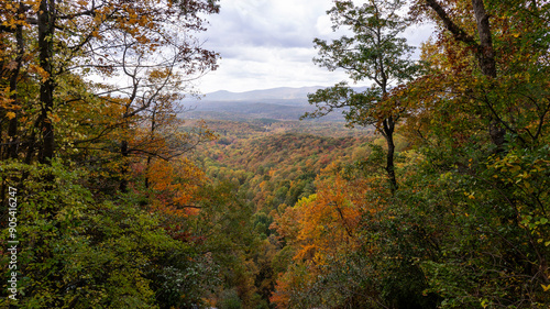 A view of the southern Appalachian mountains in peak fall foliage framed by fall trees. Photographed from the top of the falls at Amicalola Falls State Park in north Georgia.