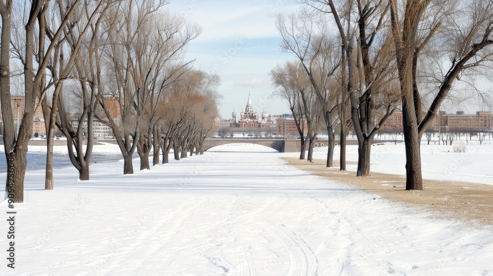 A winter landscape showcases a snowy park with trees and a historic building under a bright blue sky dotted with clouds