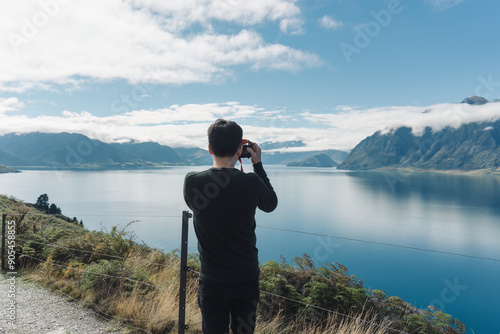 Wallpaper Mural Happy asian man taking a photo with scenic lookout of Lake Hawea in autumn Torontodigital.ca