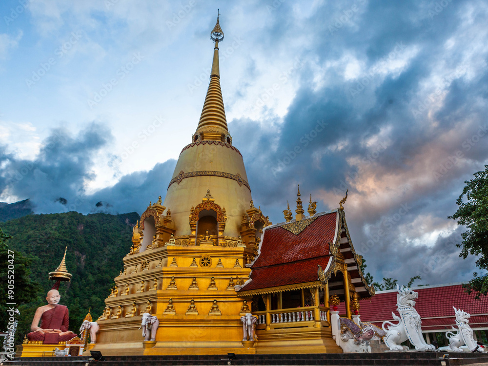 Fototapeta premium Wat Phra That Doi Chiang Dao. Chedi in Chiang Dao and monk statue of Great Master Narasabho Mahathera at sunset.