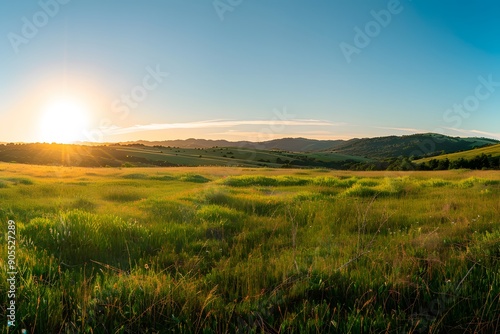 Golden sunrise over vibrant green hills and valleys.