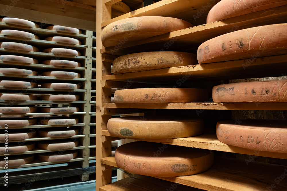 Aging rooms with shelves in cheese caves, central location for aging of wheels, rounds of Comte cheese from four months to several years made from unpasteurised cow milk, Jura, France Aging rooms with shelves in cheese caves, central location for aging of wheels, rounds of Comte cheese from four months to several years made from unpasteurised cow milk, Jura, France