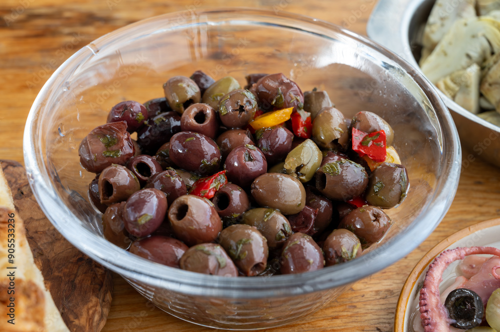 Pickled and marinated olives, artichokes, vegetables on wooden table, variety of tasty Italian starters, antipasti, tapas Pickled and marinated olives, artichokes, vegetables on wooden table, variety of tasty Italian starters, antipasti, tapas