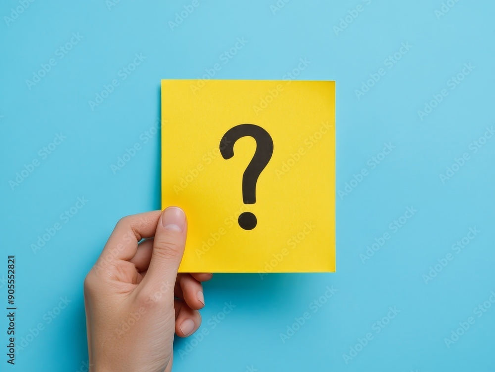 Seeking Answers: Person Holding Yellow Paper with Question Mark on Blue Background Seeking Answers: Person Holding Yellow Paper with Question Mark on Blue Background
