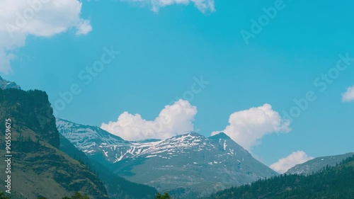 4K timelapse of mountains and clouds in blue sky at Burwa, India. Clouds time lapse. Summer mountain landscape. Travel and adventure background. Beautiful snow capped Himalayas timelapse. photo