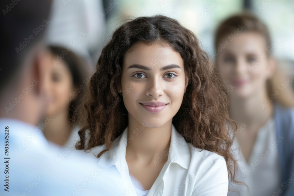 A woman with long brown hair is smiling at the camera, recruitment concept A woman with long brown hair is smiling at the camera, recruitment concept