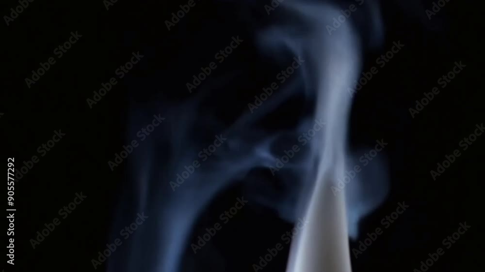 Smoke swirls and billows in slow motion against a dark background. Smoke swirls and billows in slow motion against a dark background.